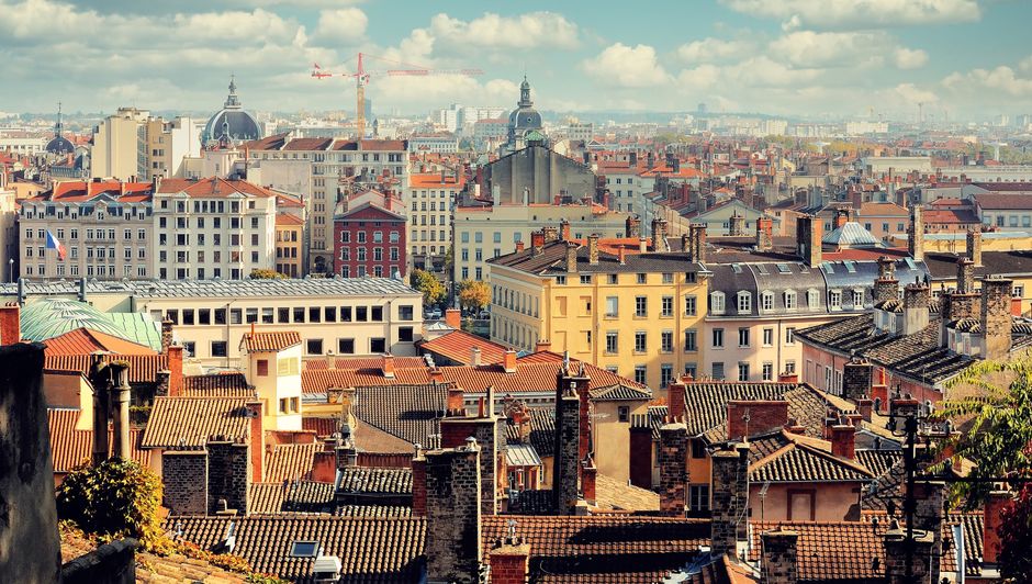marché immobilier en France — Vue aérienne des toits historiques de Lyon et de son skyline sous un ciel bleu éclatant.