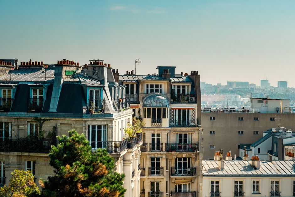 marché immobilier français — Vue pittoresque des toits parisiens classiques avec en toile de fond la skyline de la ville par