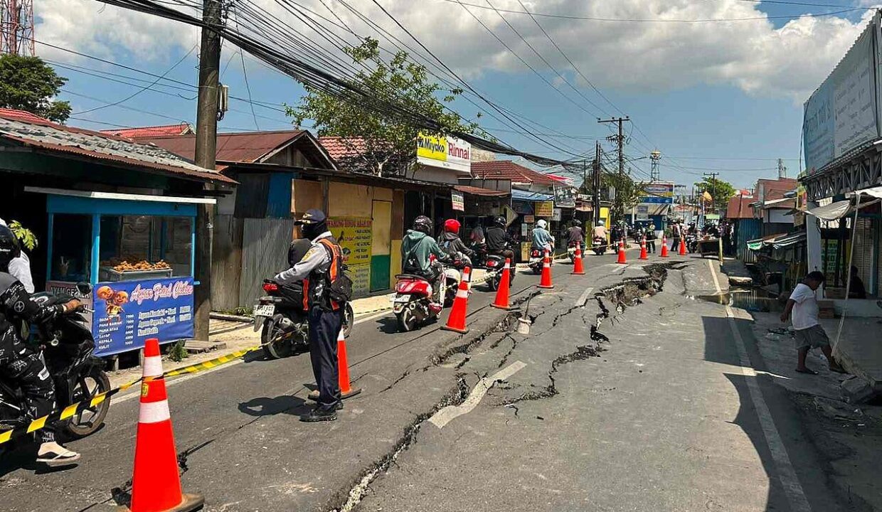 risques naturels et — Cracked Asphalt Road and Landslide Damage Caused by Natural Disaster with Traffic Officer Regulating Transportation