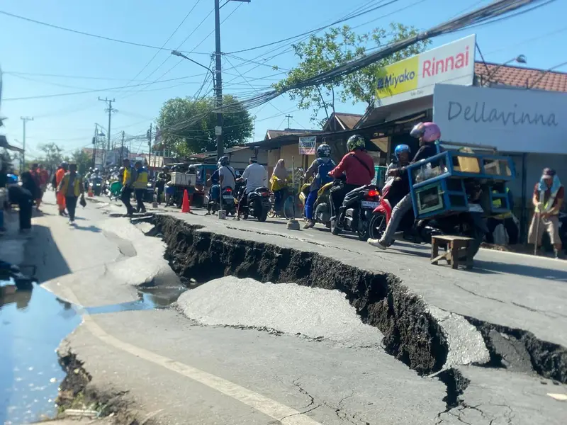 risques naturels et — Cracked Asphalt Road and Landslide Damage Caused by Natural Disaster with Traffic Officer Regulating Tra