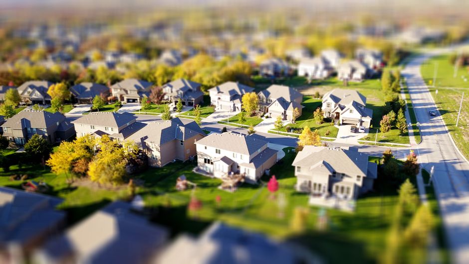 vague de chaleur — Photo aérienne en tilt-shift d'un quartier suburbain avec des pelouses vertes et des routes.